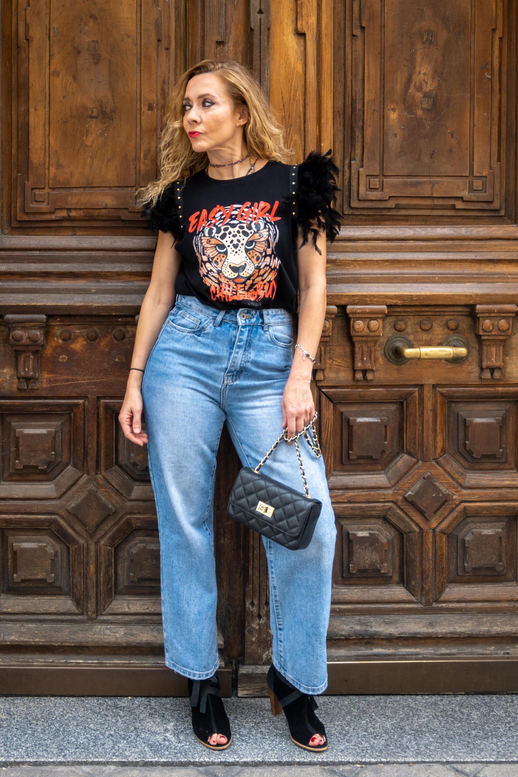 Camiseta negra con estampado de leopardo y plumas negras en los hombros, vista frontal alternativa.