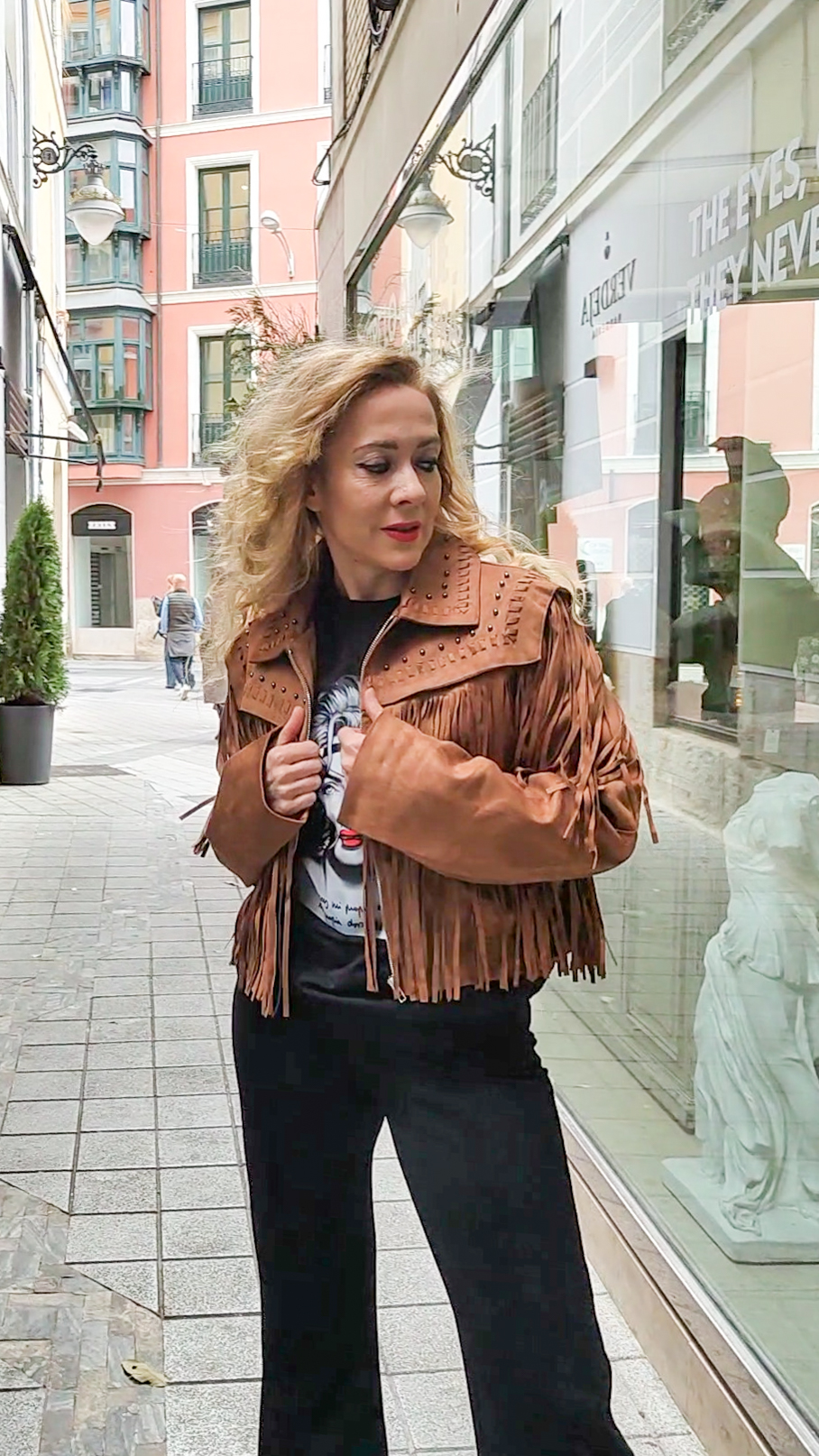 Mujer con cazadora marrón con flecos, estilo western, vista frontal completa.