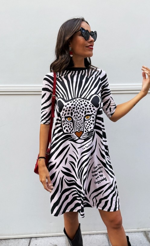 Mujer con vestido “Sueños” de media manga, corte evasé y estampado de leopardo en tela satinada elástica.
